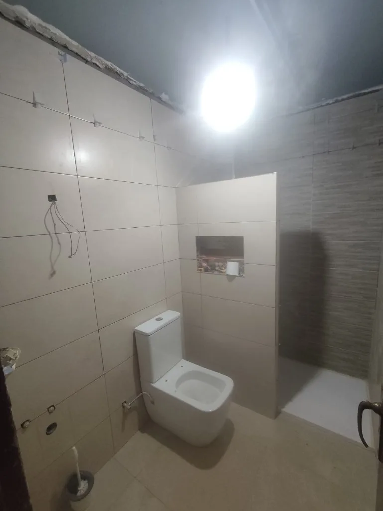 Alicatado y ducha de obra en proceso de reforma del baño